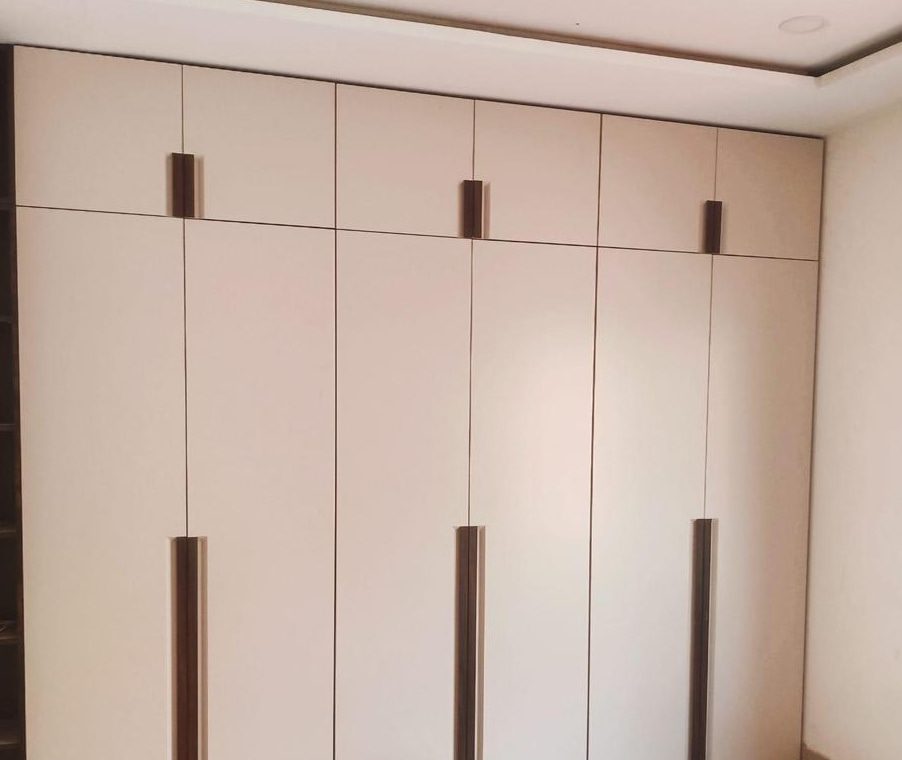 Full-height cream flat-panel wardrobe with long dark inset pulls