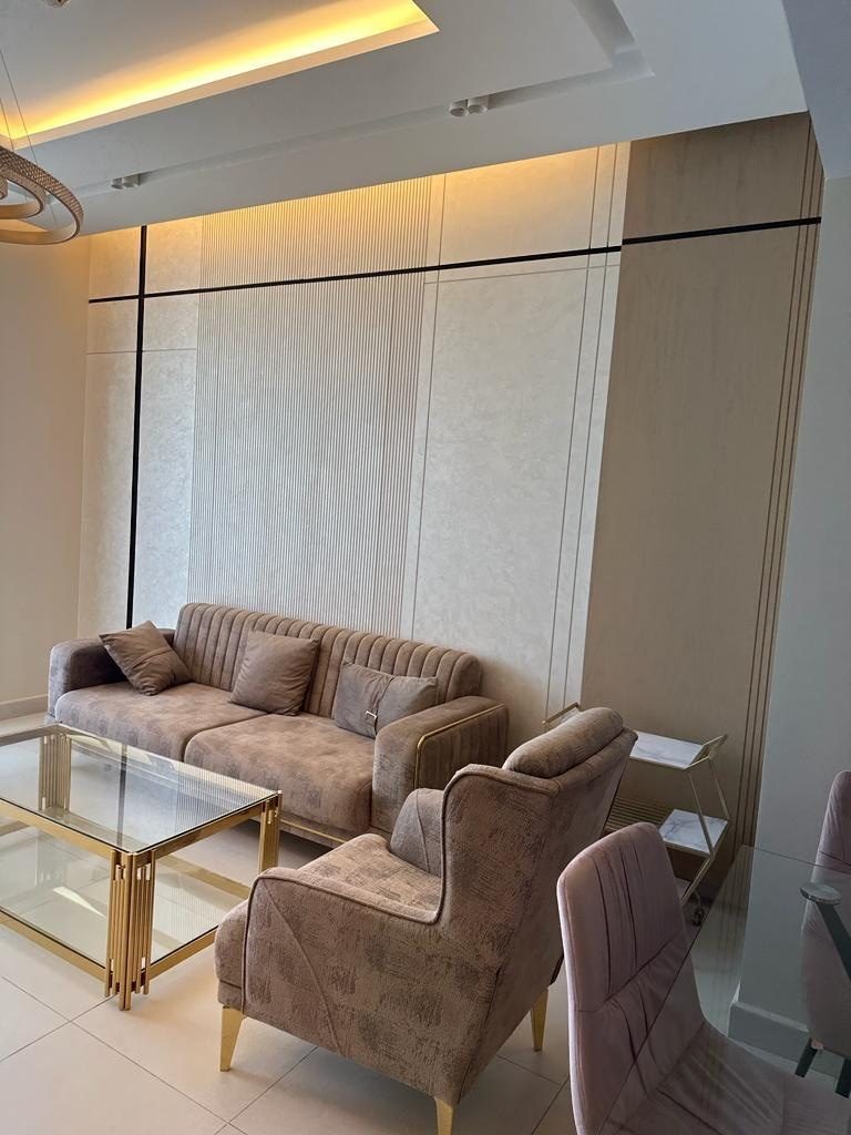 Living room lined with full-height textured cream wall panels and black inlay lines